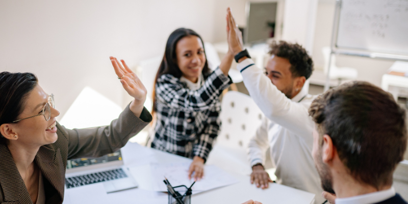Team members high-fiving each other in celebration